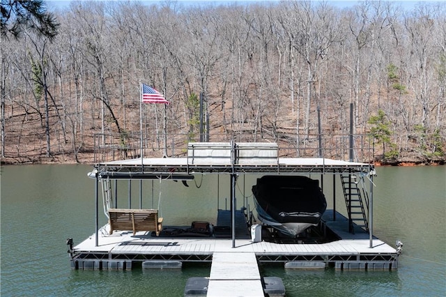 view of dock with a forest view and a water view