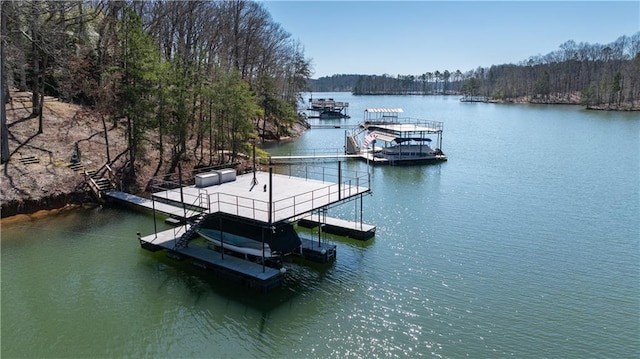 view of dock with a forest view, a water view, and boat lift