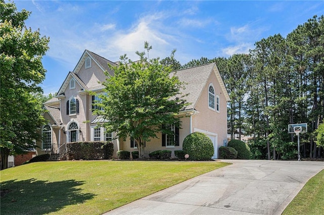 view of front facade featuring concrete driveway, a garage, a front lawn, and stucco siding