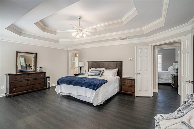 bedroom with a raised ceiling, dark wood finished floors, crown molding, baseboards, and a ceiling fan