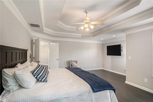 bedroom featuring a tray ceiling, wood finished floors, baseboards, ornamental molding, and ceiling fan