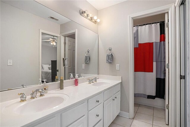 ensuite bathroom featuring tile patterned flooring, double vanity, and a ceiling fan