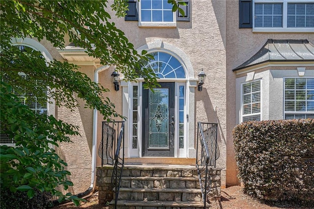view of exterior entry with stucco siding