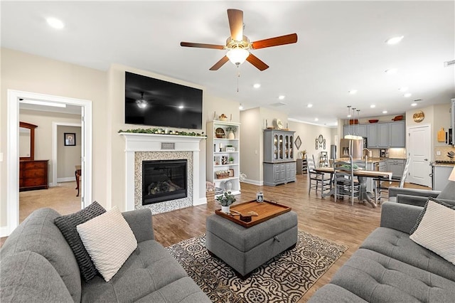 3735 Westhaven Dr, Cumming, GA 30040 - living room featuring a ceiling fan, light wood-style flooring, recessed lighting, and a glass covered fireplace