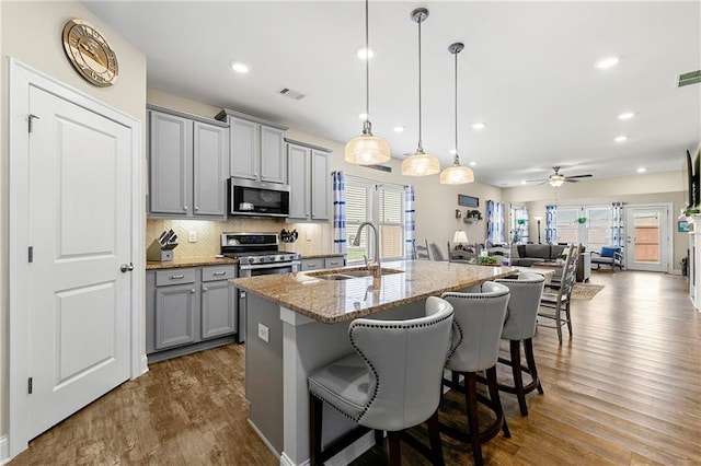 3735 Westhaven Dr, Cumming, GA 30040 - kitchen featuring gray cabinets, appliances with stainless steel finishes, dark wood-style flooring, a center island with sink, and recessed lighting