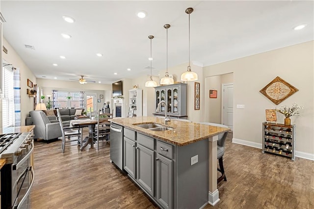 3735 Westhaven Dr, Cumming, GA 30040 - kitchen with gray cabinetry, stainless steel appliances, ceiling fan, light stone counters, and a kitchen island with sink