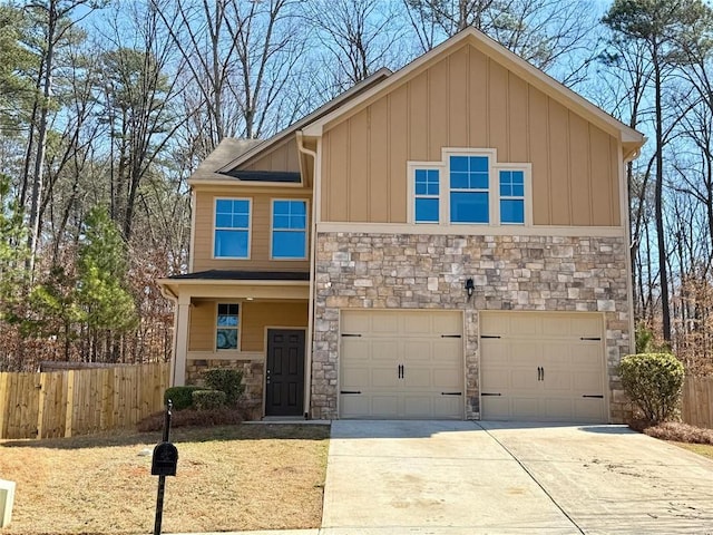 view of front of home featuring a garage, driveway, stone siding, fence, and board and batten siding