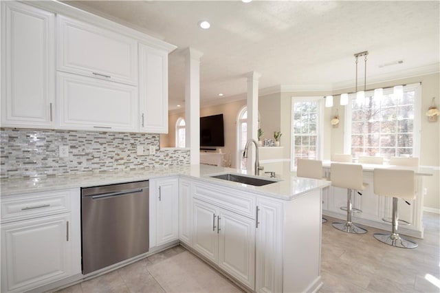 kitchen featuring a sink, a peninsula, white cabinetry, and dishwasher