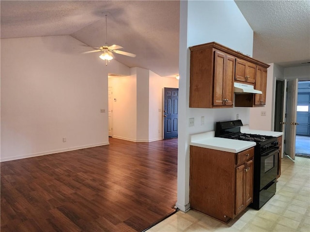 kitchen featuring light wood-type flooring, a textured ceiling, lofted ceiling, ceiling fan, and black gas range