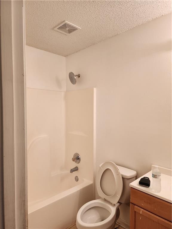 full bathroom featuring bathtub / shower combination, a textured ceiling, vanity, and toilet