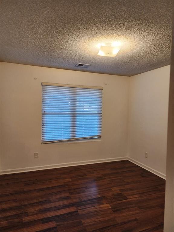 835 Amelia Grove Ln, Lawrenceville, GA 30045 - unfurnished room featuring dark wood-type flooring, a textured ceiling, visible vents, and baseboards
