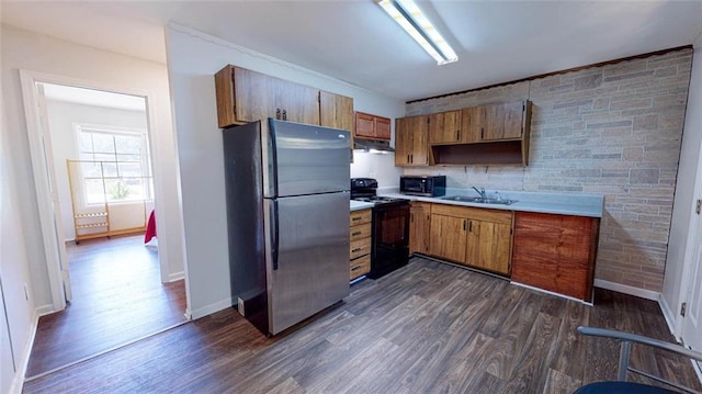 kitchen with dark wood-type flooring, sink, black electric range, and stainless steel refrigerator