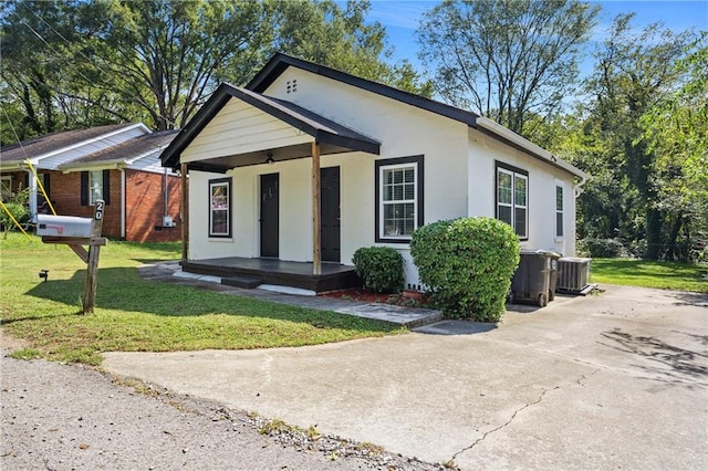 view of front of house with a front yard and central air condition unit