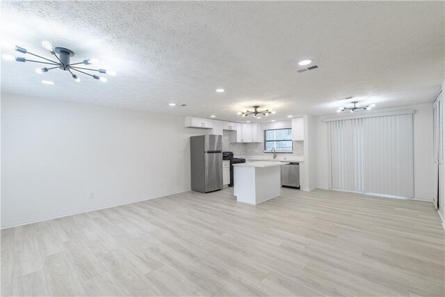 4922 Glenside Ct, Stone Mountain, GA 30088 - unfurnished living room with a chandelier, a textured ceiling, recessed lighting, light wood finished floors, and a sink