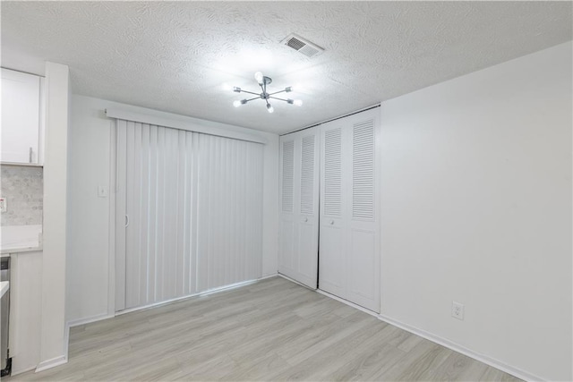 4922 Glenside Ct, Stone Mountain, GA 30088 - unfurnished living room featuring light wood-type flooring, a textured ceiling, and baseboards