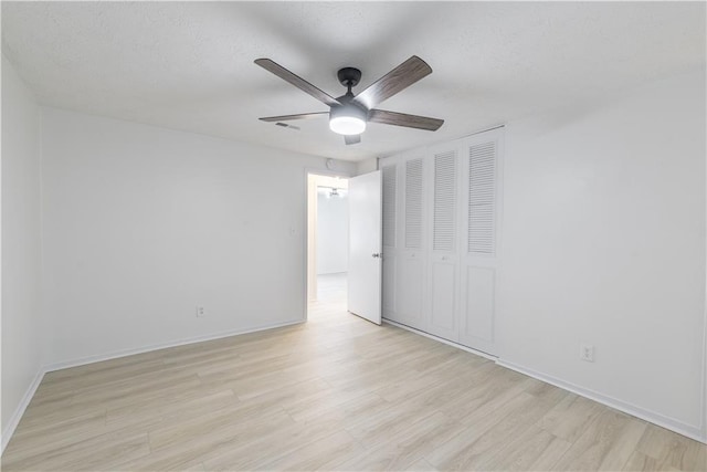 4922 Glenside Ct, Stone Mountain, GA 30088 - unfurnished bedroom featuring light wood-style floors, a closet, baseboards, a ceiling fan, and a textured ceiling