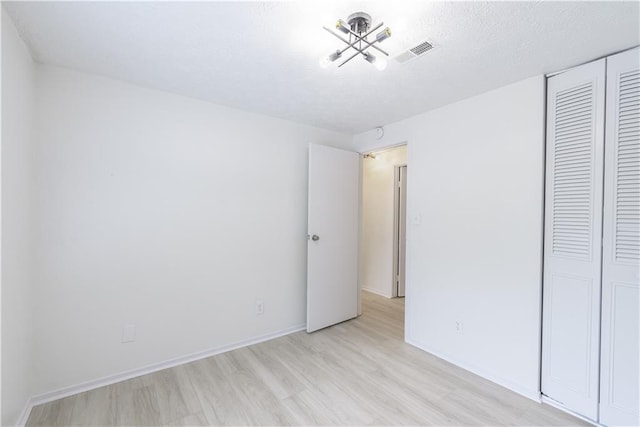 4922 Glenside Ct, Stone Mountain, GA 30088 - unfurnished bedroom with light wood-type flooring, a closet, baseboards, and a chandelier