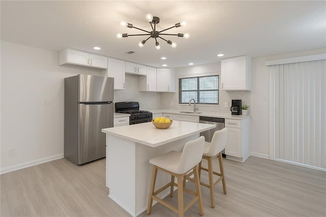 4922 Glenside Ct, Stone Mountain, GA 30088 - kitchen with stainless steel appliances, a sink, a chandelier, light wood-style floors, and white cabinets
