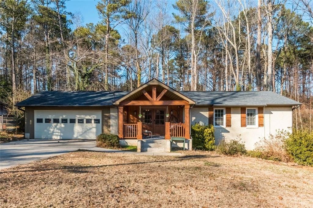 view of front of house featuring a garage, covered porch, and a front yard