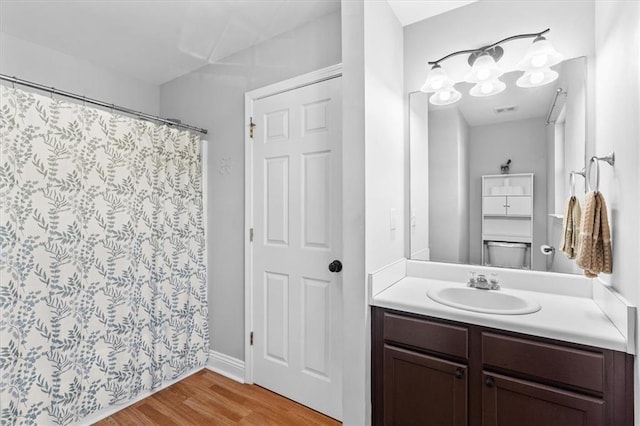 full bathroom with curtained shower, vanity, and wood finished floors