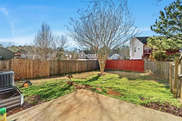 view of yard with a fenced backyard, central AC, and a patio