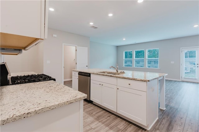 kitchen featuring stainless steel dishwasher, a sink, light wood-type flooring, white cabinets, and recessed lighting