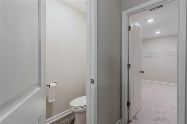 bathroom featuring toilet, baseboards, and recessed lighting