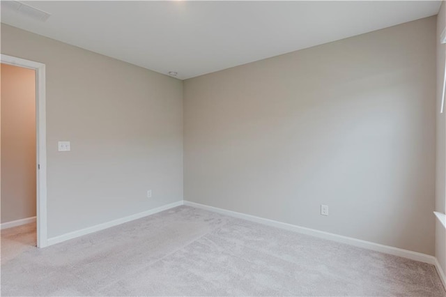 spare room with light carpet and baseboards