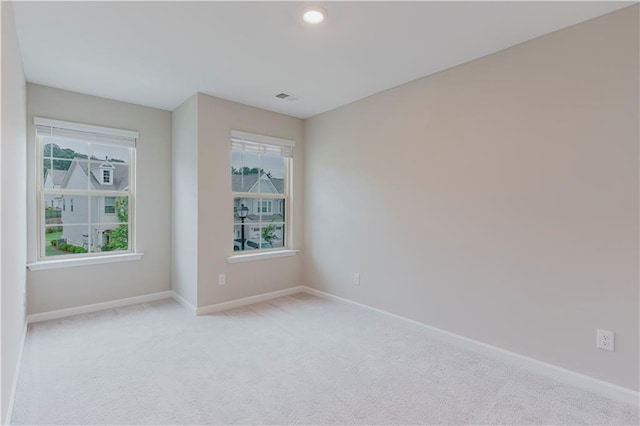 unfurnished room featuring baseboards and light colored carpet