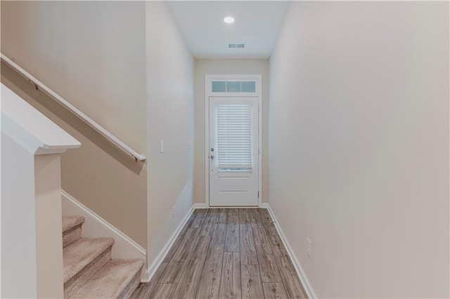 doorway featuring wood finished floors, stairway, baseboards, and recessed lighting