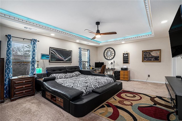 bedroom with a tray ceiling, ceiling fan, and light carpet