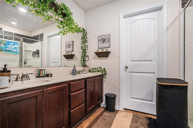 bathroom with hardwood / wood-style floors, vanity, and walk in shower