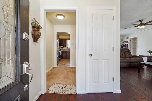 interior space with a textured ceiling, baseboards, and wood finished floors