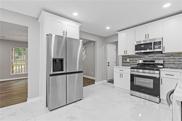 2599 Willow Creek Dr, Duluth, GA 30096 - kitchen featuring stainless steel appliances, baseboards, light marble finish floors, decorative backsplash, and recessed lighting