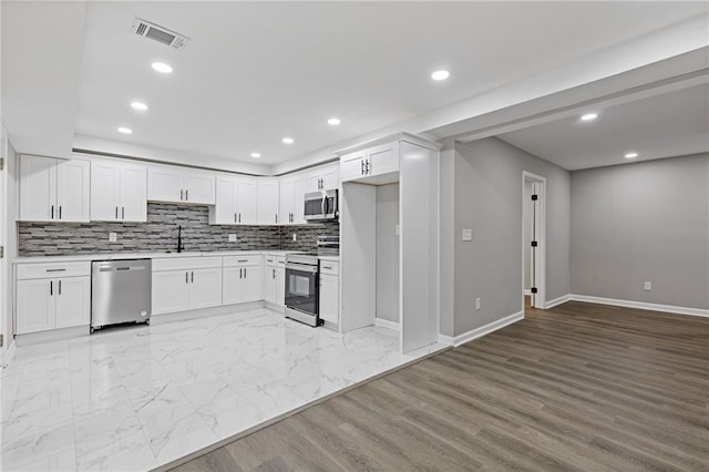 2599 Willow Creek Dr, Duluth, GA 30096 - kitchen with stainless steel appliances, baseboards, light countertops, recessed lighting, and a sink
