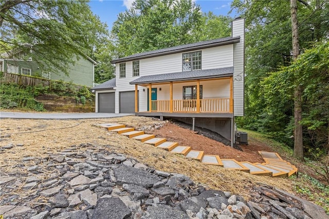 2599 Willow Creek Dr, Duluth, GA 30096 - view of front of home with covered porch, a chimney, concrete driveway, central air condition unit, and an attached garage