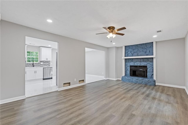 2599 Willow Creek Dr, Duluth, GA 30096 - unfurnished living room with ceiling fan, light wood-style flooring, a sink, recessed lighting, and a fireplace
