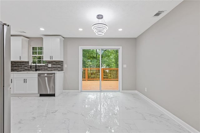 2599 Willow Creek Dr, Duluth, GA 30096 - kitchen featuring stainless steel dishwasher, white cabinetry, light marble finish floors, freestanding refrigerator, and baseboards
