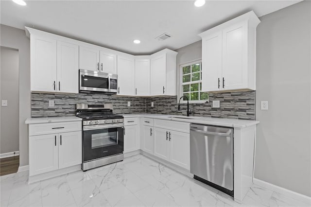 2599 Willow Creek Dr, Duluth, GA 30096 - kitchen with appliances with stainless steel finishes, baseboards, recessed lighting, a sink, and light marble finish floors