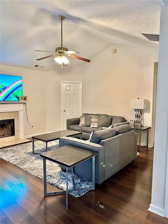 living area featuring a premium fireplace, wood finished floors, a ceiling fan, visible vents, and lofted ceiling