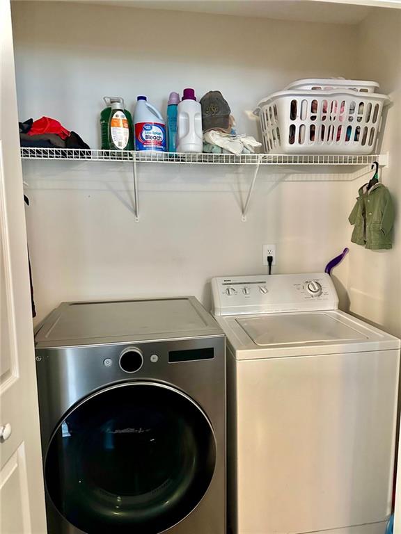 clothes washing area with separate washer and dryer and laundry area