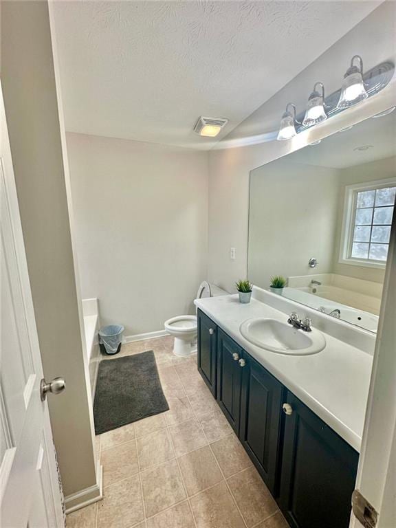 bathroom with toilet, a textured ceiling, a washtub, and vanity