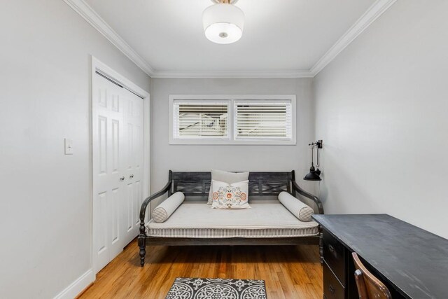 sitting room with hardwood / wood-style flooring and ornamental molding