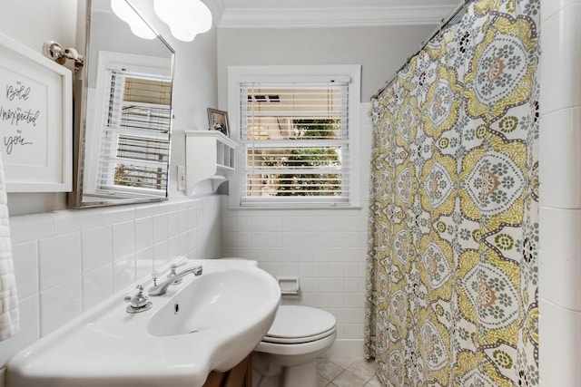 bathroom with tile patterned flooring, toilet, tile walls, and crown molding