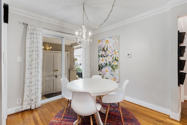 dining space with hardwood / wood-style flooring and crown molding