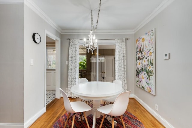 dining room with crown molding, a notable chandelier, and hardwood / wood-style flooring