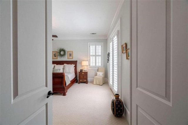 bedroom with light colored carpet and ornamental molding