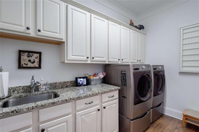 washroom with washer and clothes dryer, cabinet space, wood finished floors, ornamental molding, and baseboards