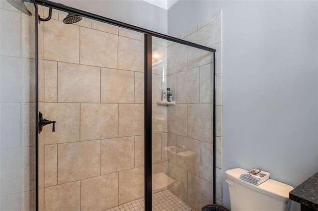 bathroom featuring toilet and a stall shower