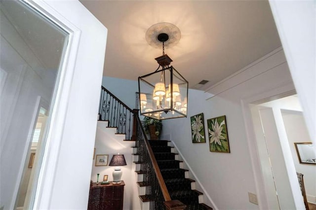 staircase featuring a chandelier